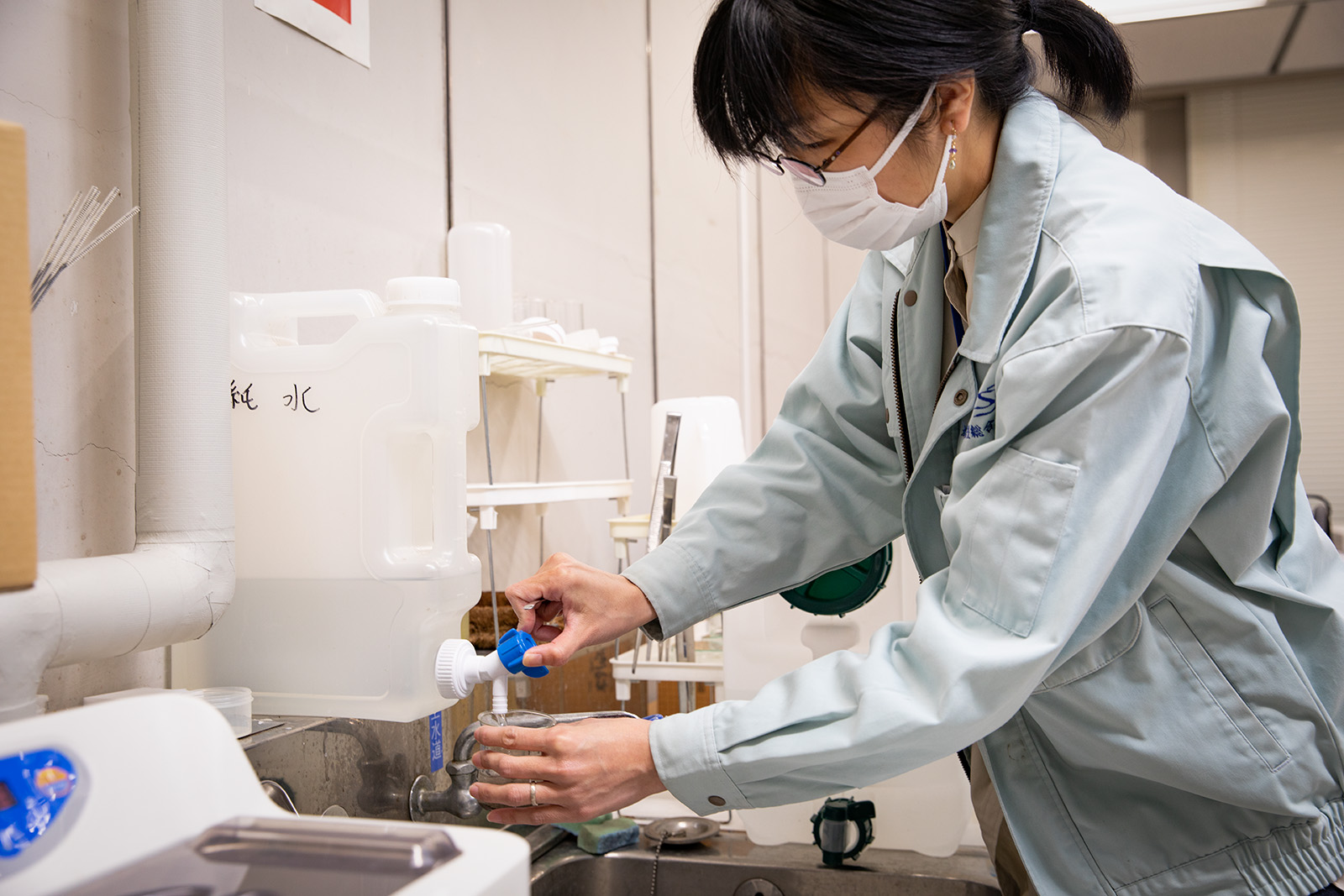 火山灰試料に水を注ぐ研究者