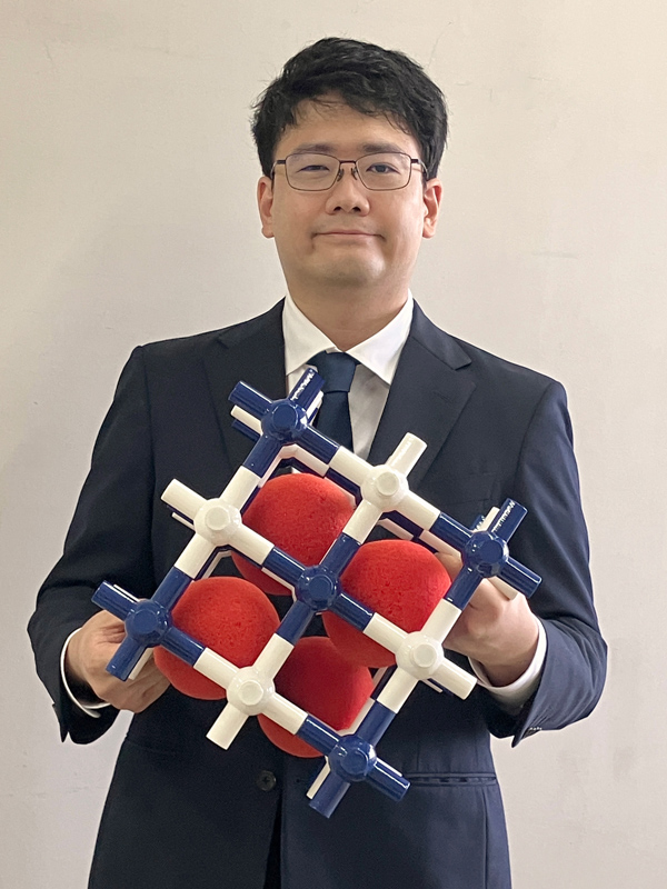 「プルシアンブルー型錯体」の分子模型を持った山口さん